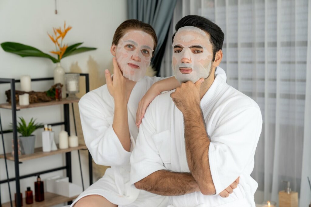 Mulher e homem com máscara facial e roupão em um banheiro
