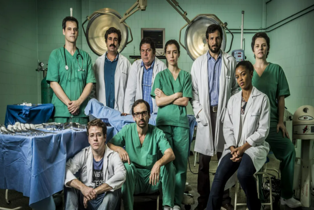 grupo de médicos posam para foto em uma sala de cirurgia 
