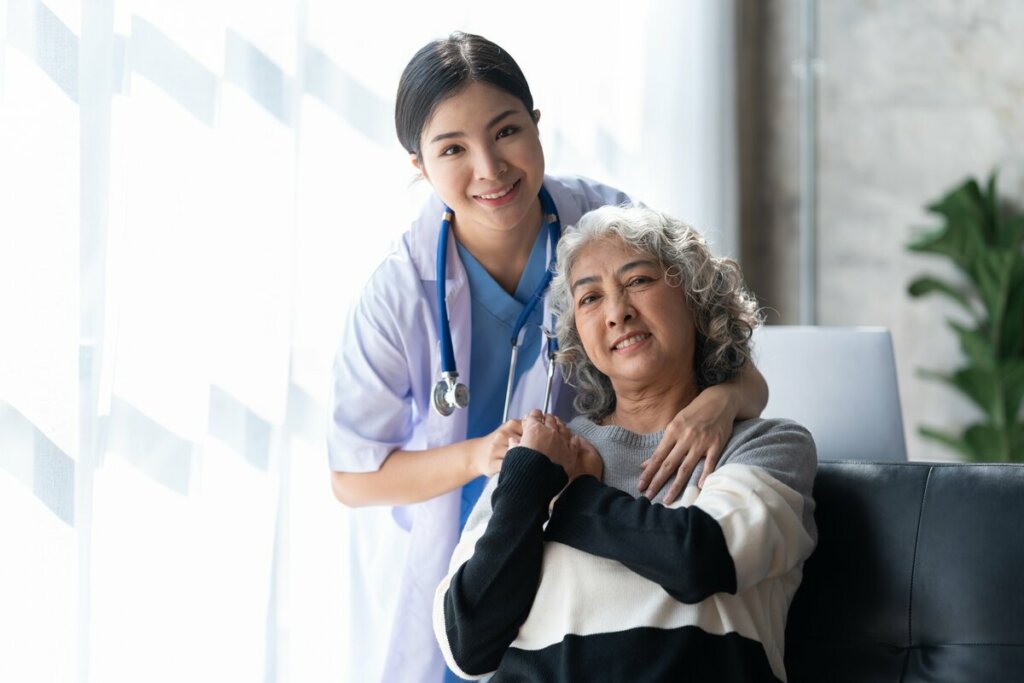 Médica abrançando uma mulher sentada