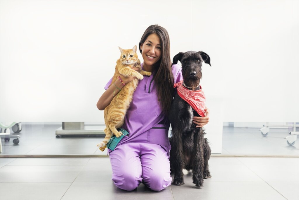 Veterinária com gato e cachorro ao lado