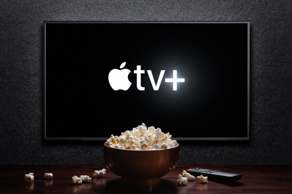 Televisão com logo da Apple TV+ e pote de pipoca à frente