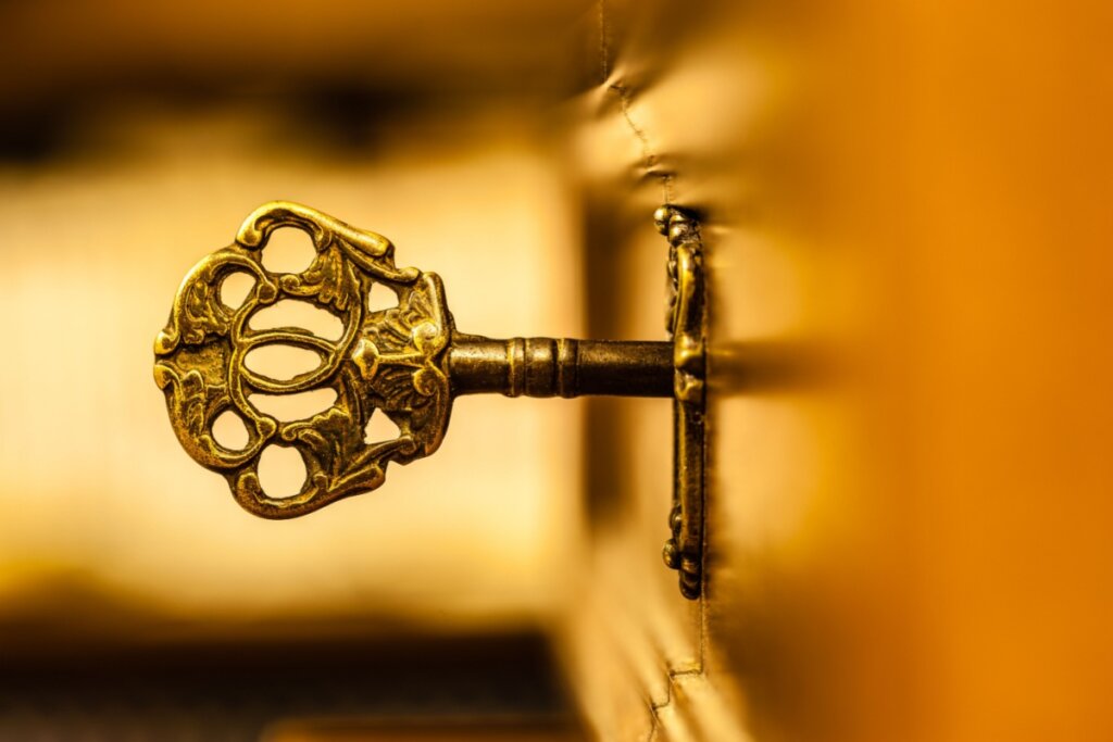 Chave de metal antiga em tons de dourado em fechadura 