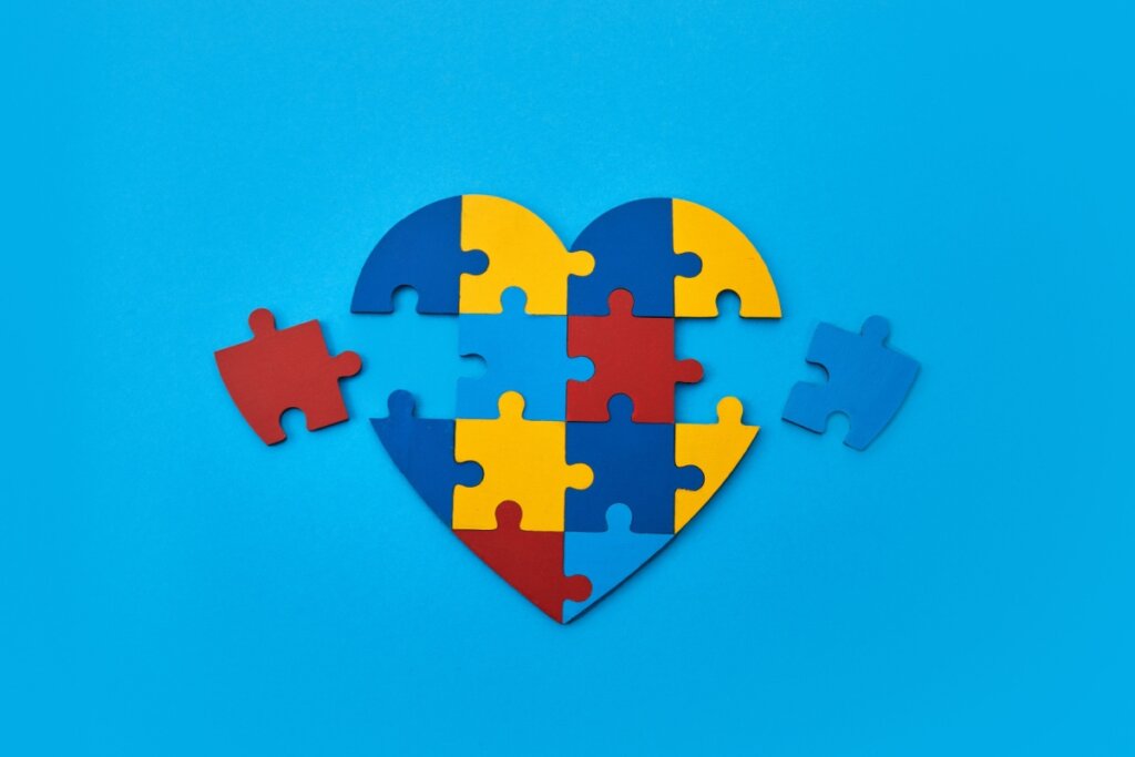 coração em quebra cabeça com as cores que representam o autismo