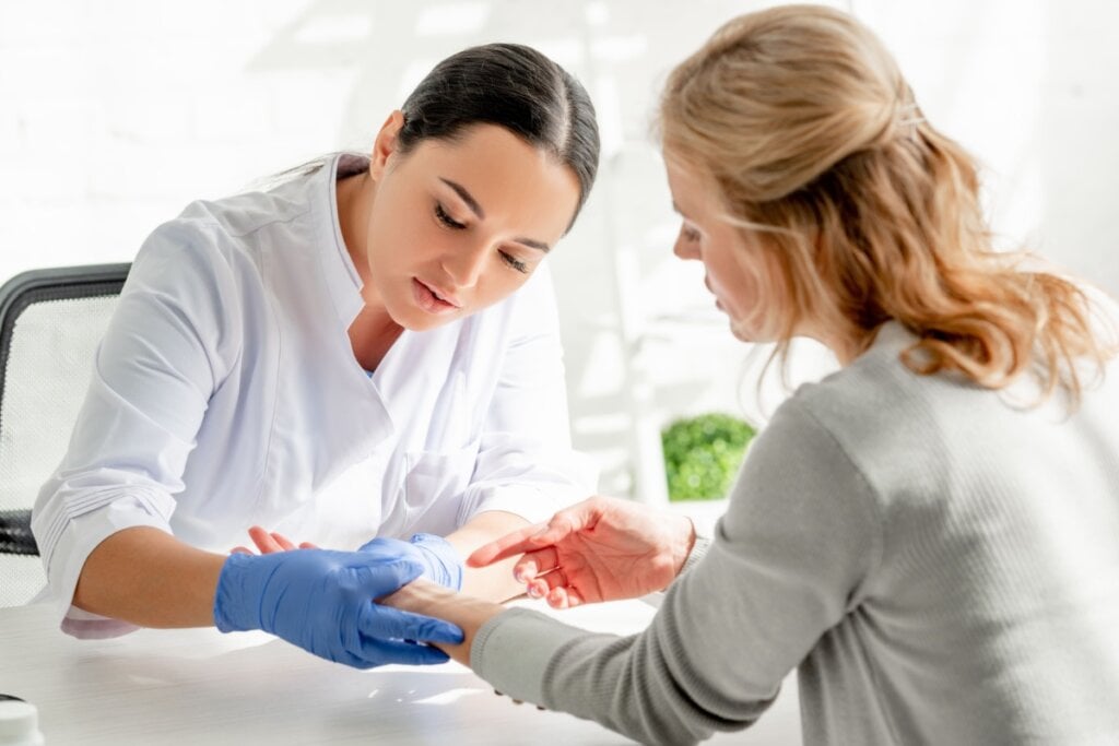 Médica examinando braço de paciente