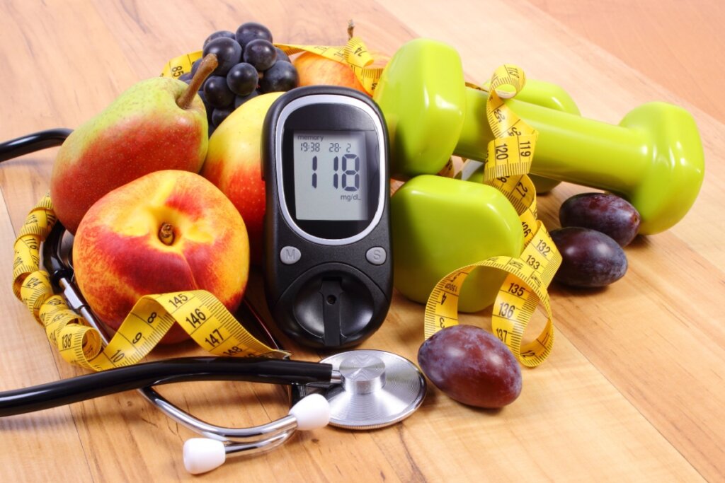 Medidor de glicose, frutas e halteres ao redor