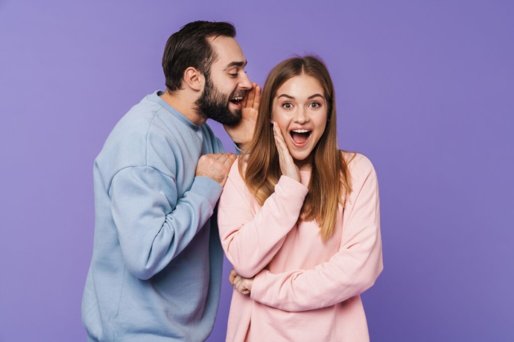 homem falando no ouvido da mulher uma mentira