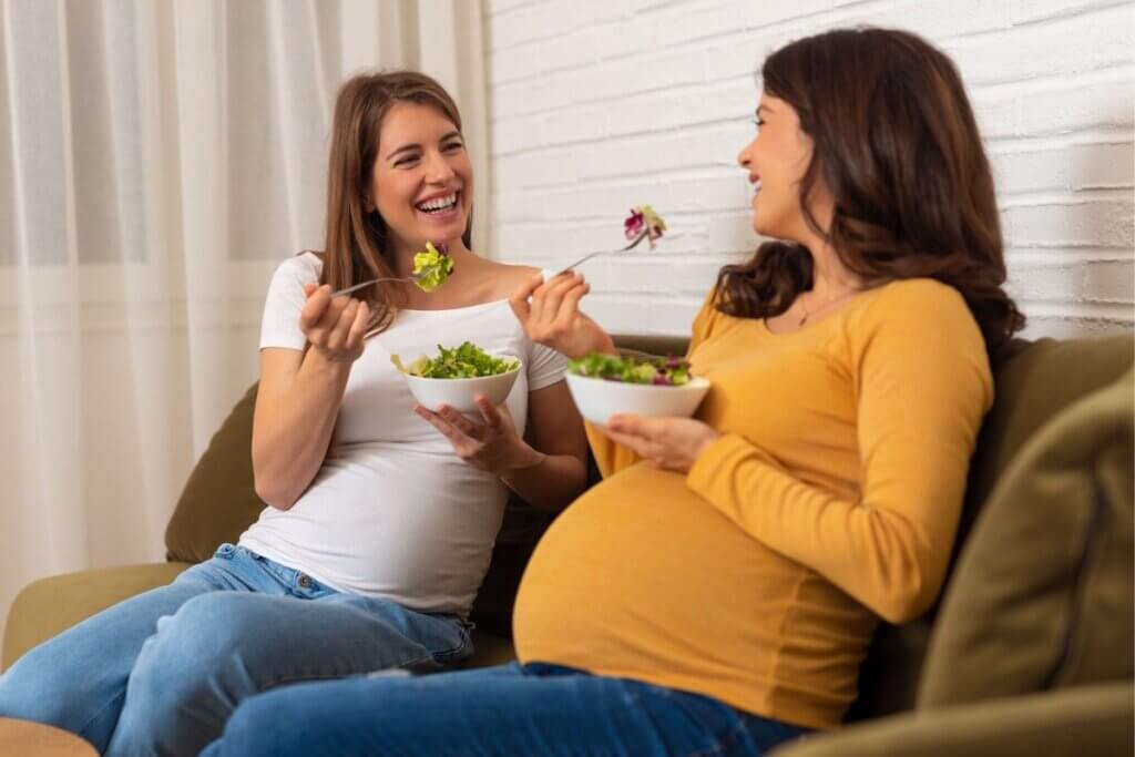 Duas gravidas sentadas comendo