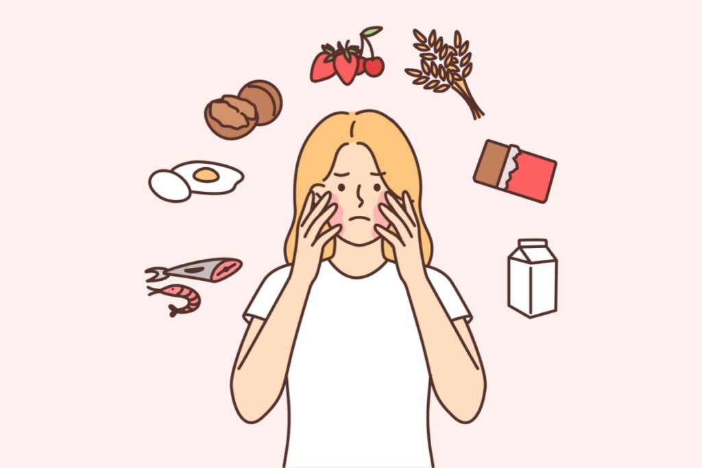 Ilustração de uma mulher loira com as mãos no rosto cobrindo machas vermelhas. Em volta dela tem um círculo com alimentos que costumam causar reações alérgicas, como ovo, peixe, leite e chocolate.