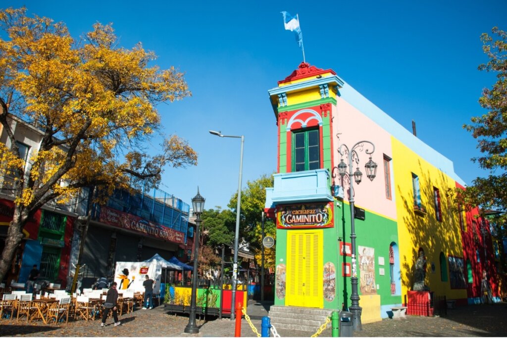 Rua em Bueno Aires, Argentina, cm casa colorida e mesas e cadeiras ao lado