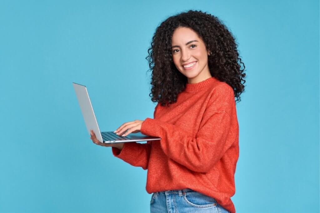 Mulher sorrindo mexendo em um notebook