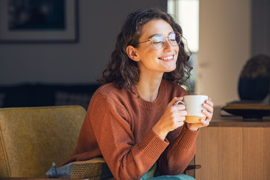 Mulher sorrindo segurando uma caneca