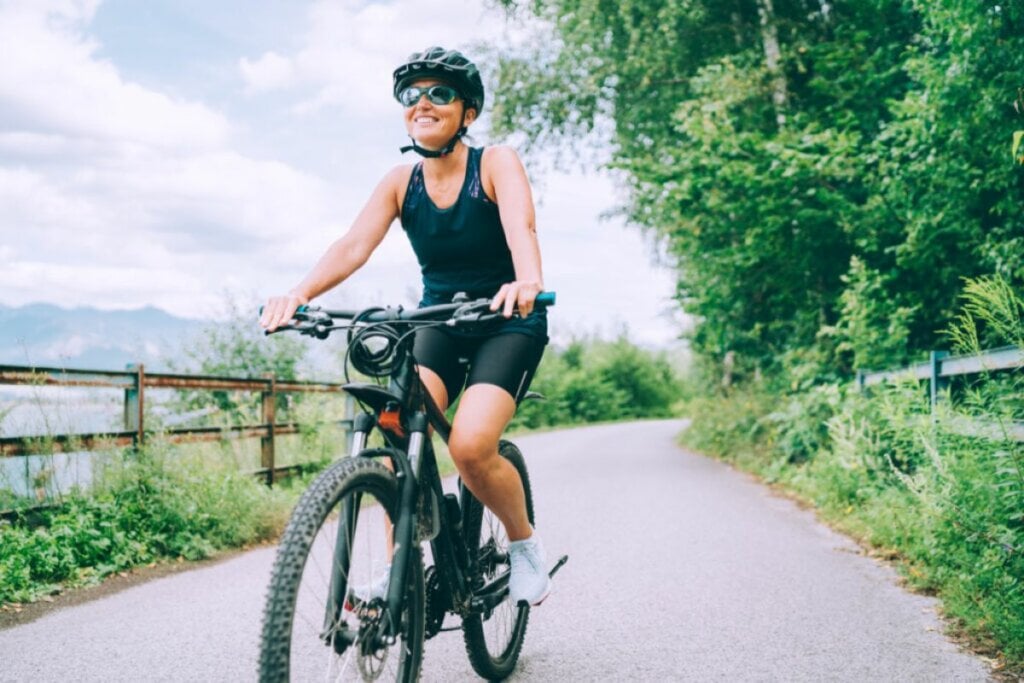 Mulher com roupa de ciclismo andando de bicicleta