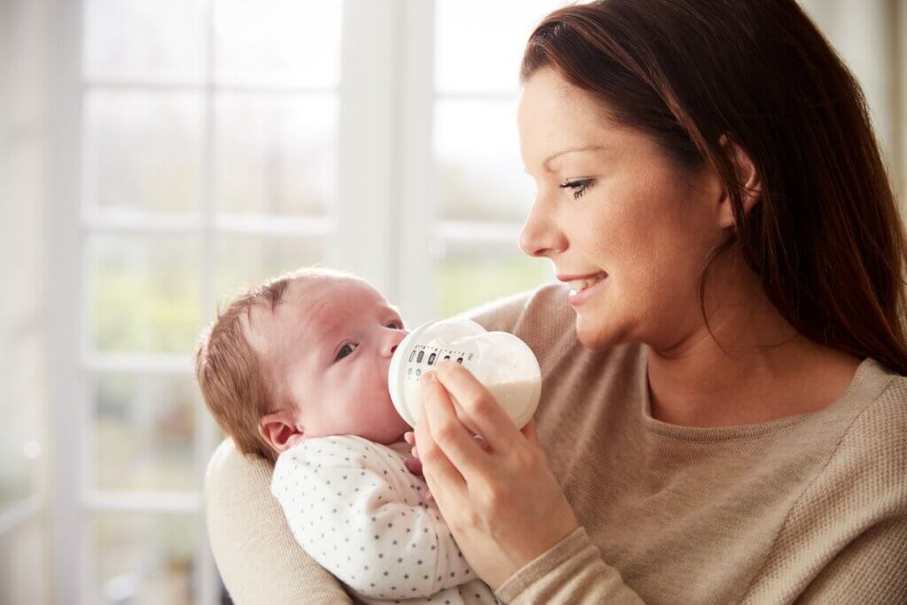 Mulher dando mamadeira para um bebê