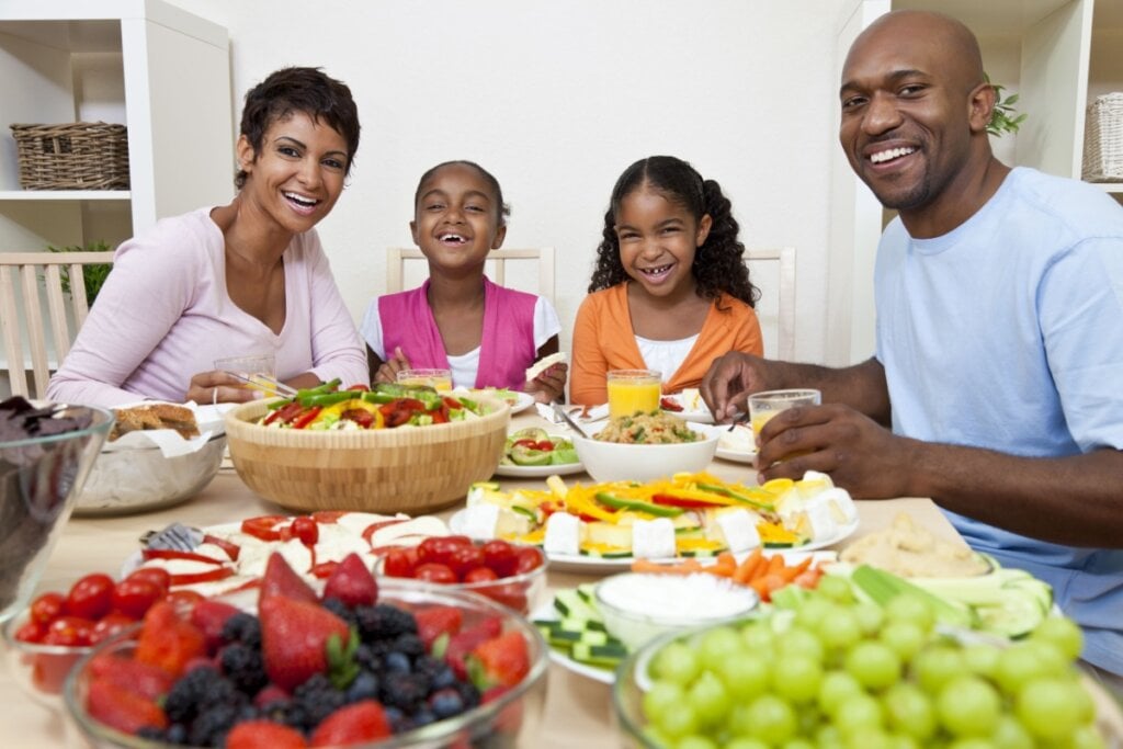 Família sorrindo fazendo alimentação saudável