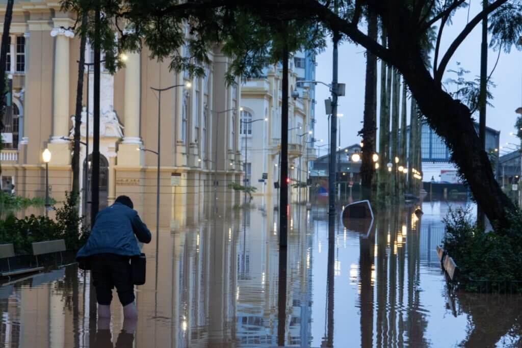 Imagem do centro de Porto Alegre alagada após as chuvas de abril e maio; uma pessoa andando na água.