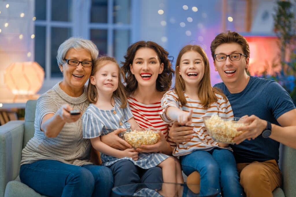 Família assistindo à TV comendo pipoca