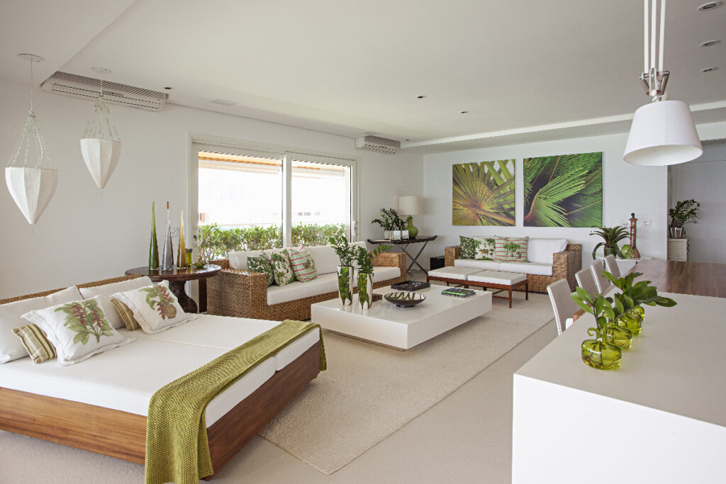 Sala de estar com sofás brancos com madeira e plantas em mesa de centro branca