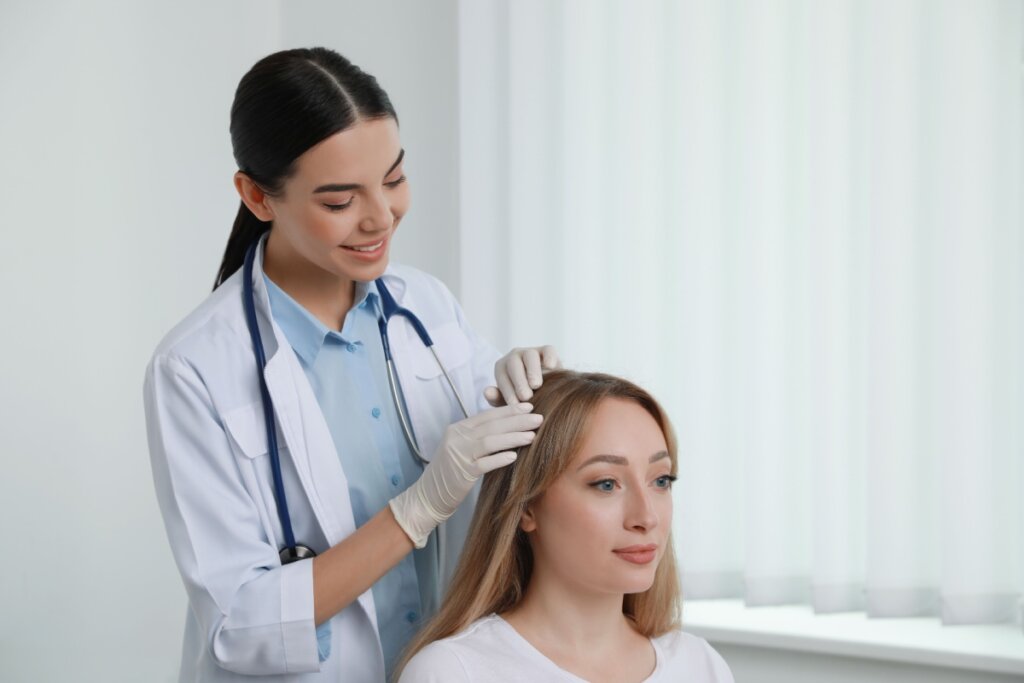 Médica examinando couro cabeludo de paciente mulher