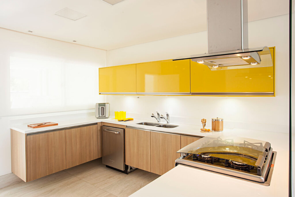 Imagem de cozinhe com armário alto amarelo e armários baixos em tom marrrom