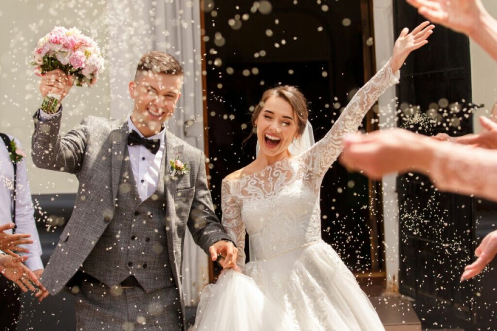Casal feliz após casar saindo de uma igreja 