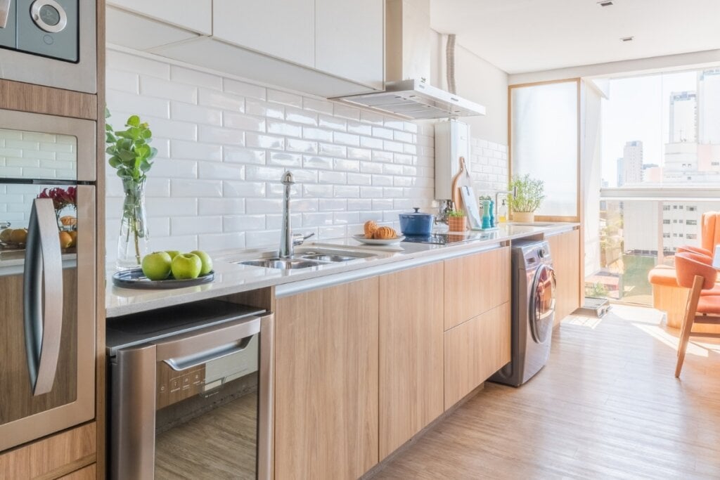 Cozinha com azulejo branco e móveis de madeira