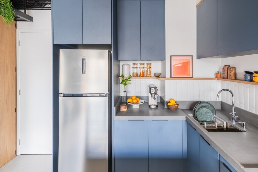 Cozinha com móveis azuis e azulejo branco 