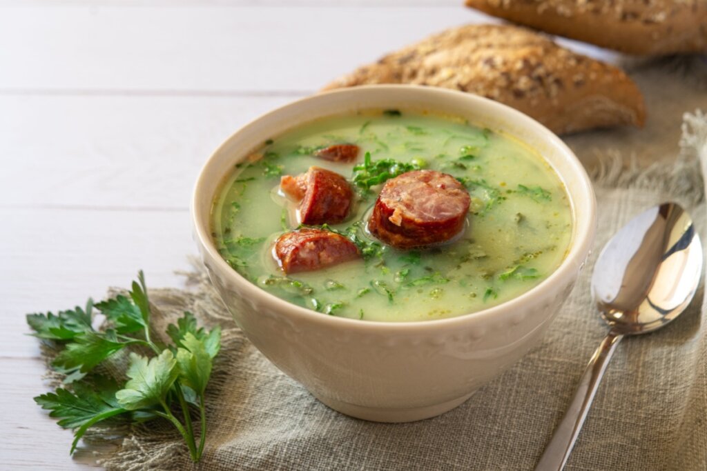 Caldo verde em cumbuca em cima de uma mesa