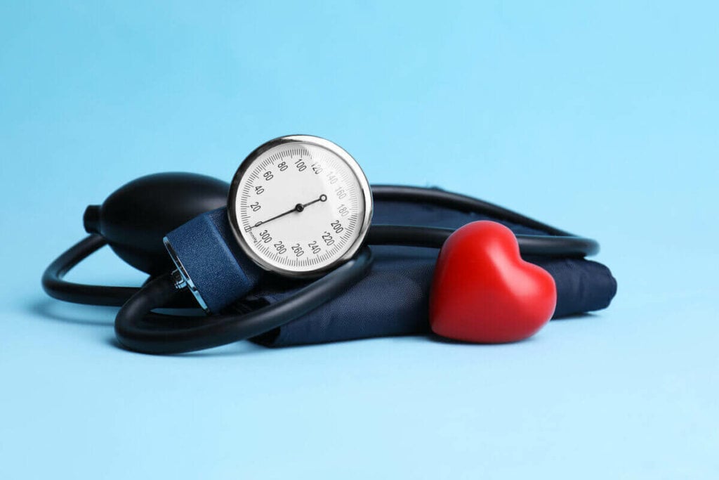 Medidor de pressão arterial e um coração de borracha em cima de um fundo azul