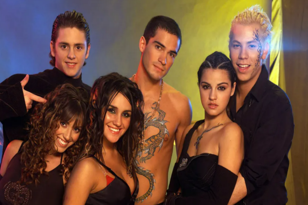 5 pessoas uma ao lado da outra posando para foto - integrantes da banda RBD - há três mulheres e três homens na foto. 