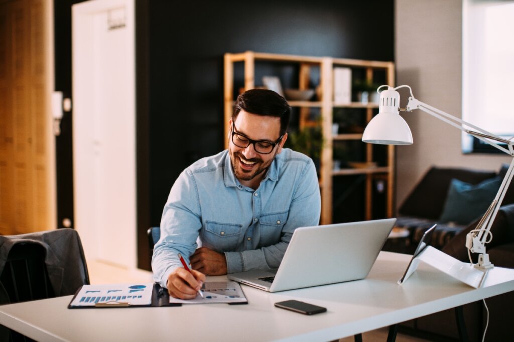 Homem freelancer trabalhando em sua mesa com notebook e outros itens