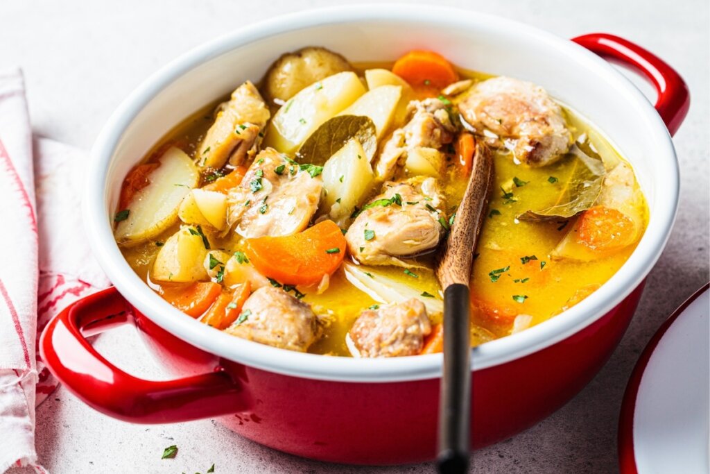 Panela vermelha com ensopado de frango, batata e cenoura