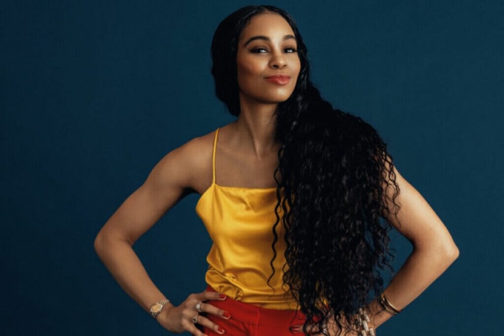 Mulher com cabelo longo e mãos na cintura posando para foto