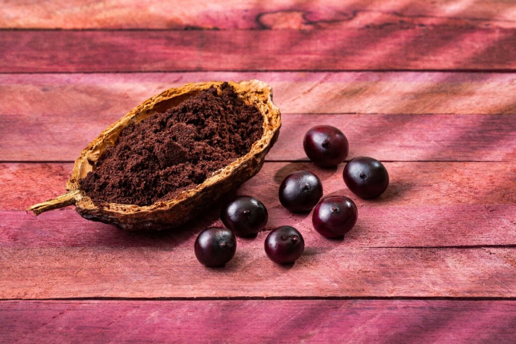 Açaí ao lado de seu pó sobre uma superfície de madeira