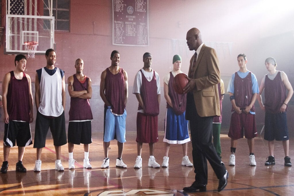Treinador falando com o time de basquete em uma quadra de basquete 