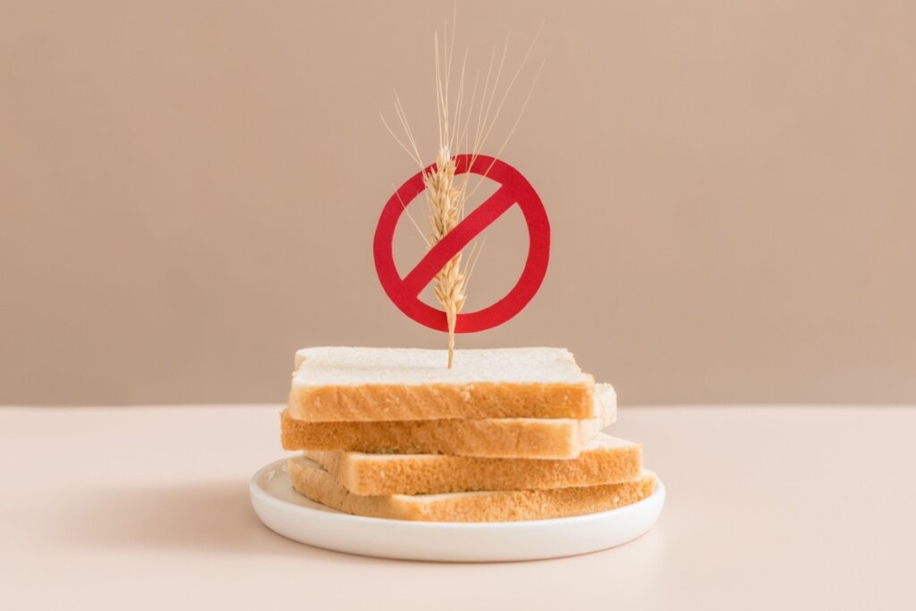 Prato com fatias de pão branco e um símbolo de proibição com um ramo de trigo