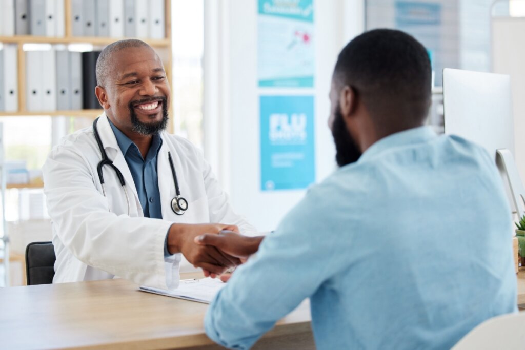 Homem conversando com médico em consultório