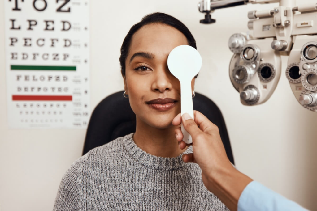 mulher em consultório de oftalmologista fazendo teste de visão
