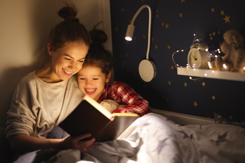 Mãe e filha lendo no quarto