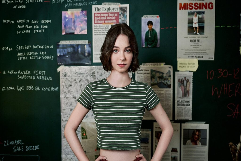 Menina com uma camiseta listrada verde com mural com pistas de uma investigação
