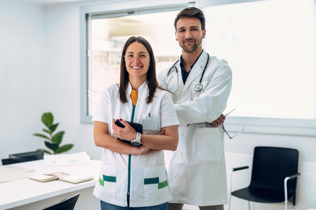 Dois médicos uniformizados sorrindo