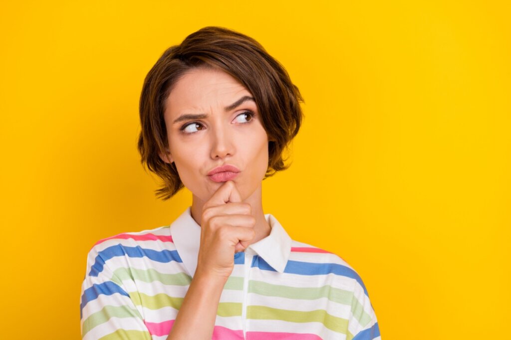 mulher em um fundo amarelo olhando de forma suspeita