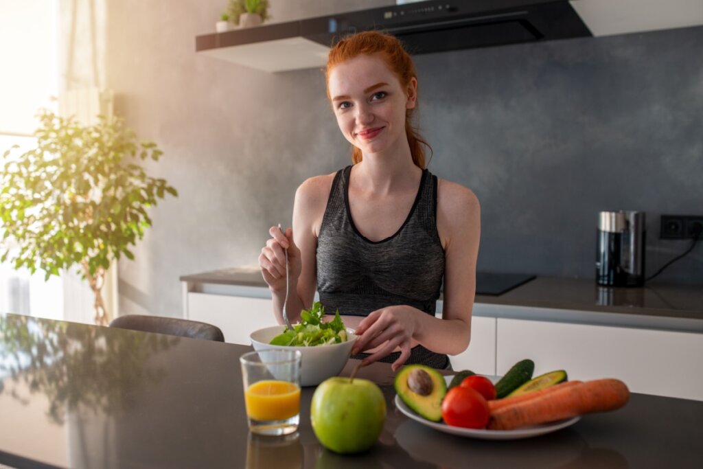 mulher preparando salada em cozinha