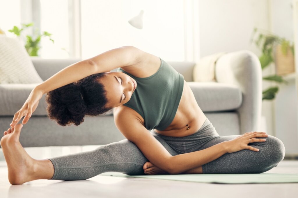 Mulher praticando pilates em um tapete de exercício na sala