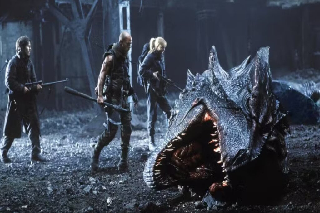Cena do filme "Reino de Fogo"; jovens e cabeça de dragão na cena