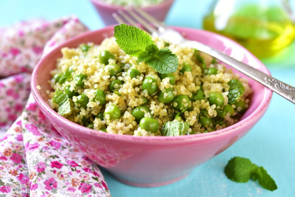 salada de ervilha e quinoa em um bowl rosa em cima de uma mesa