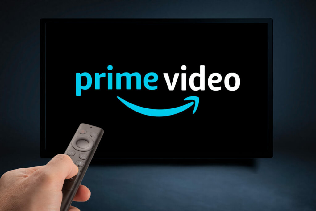 tv com Prime Video e mão com controle remoto