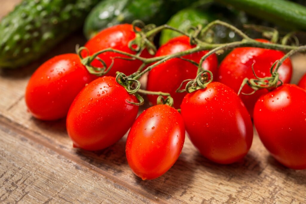 Tomates italianos presos no ramo em cima de uma mesa de madeira