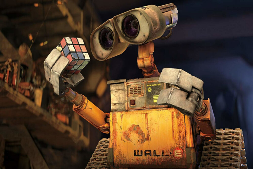 WALL-E segurando um cubo mágico em sua garra, em meio a um ambiente repleto de objetos curiosos e peças mecânicas