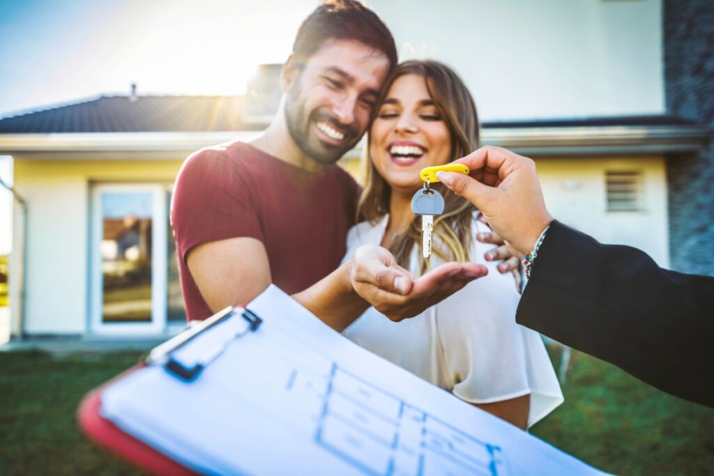 Mulher e homem felizes recebendo chave de casa