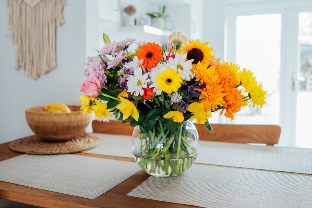 Flores em um vaso de planta em cima de uma mesa